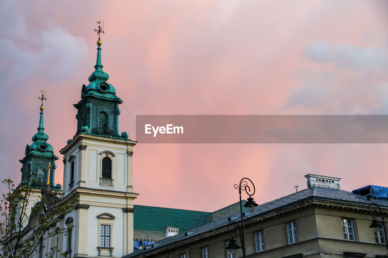 Low angle view of building against cloudy sunset sky