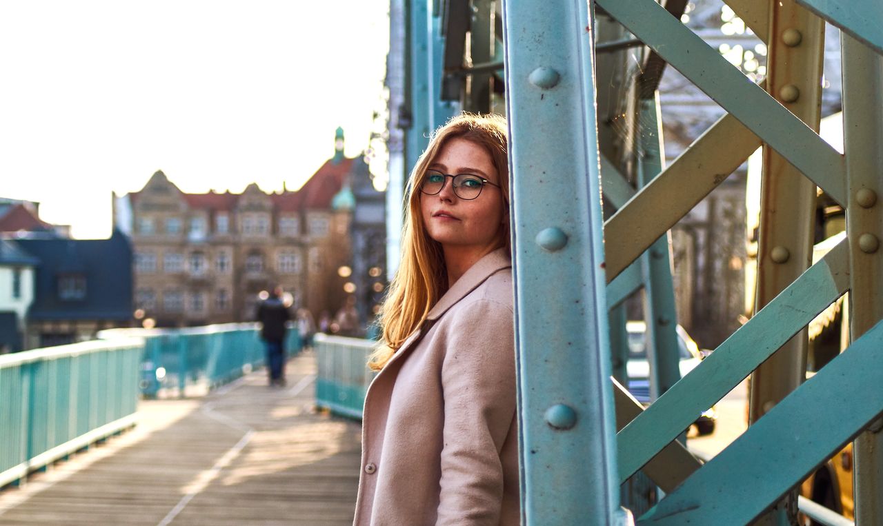 Portrait of smiling woman standing on bridge