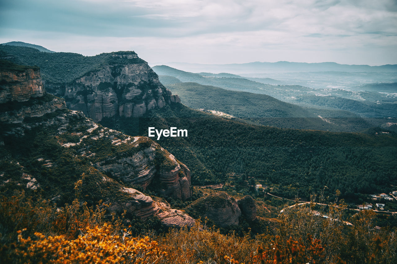 Scenic view of land and mountains against sky