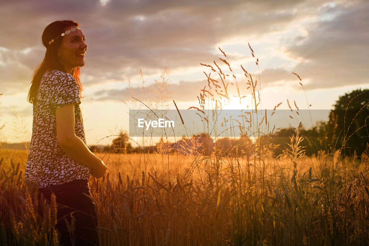 Woman in wheat at sunset