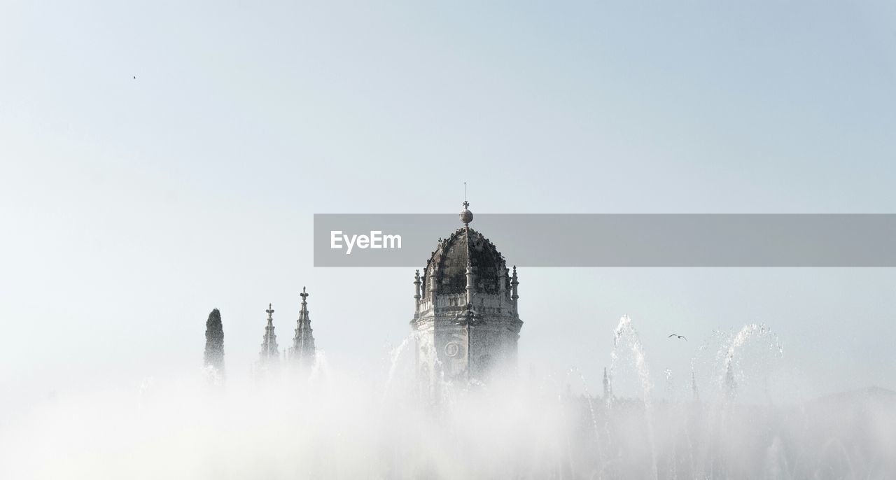 High section of mosteiro dos jeronimos against sky during foggy weather