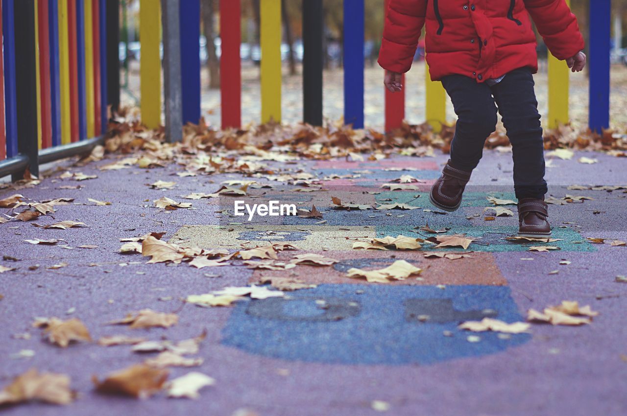 Low section of child playing hopscotch at playground during autumn