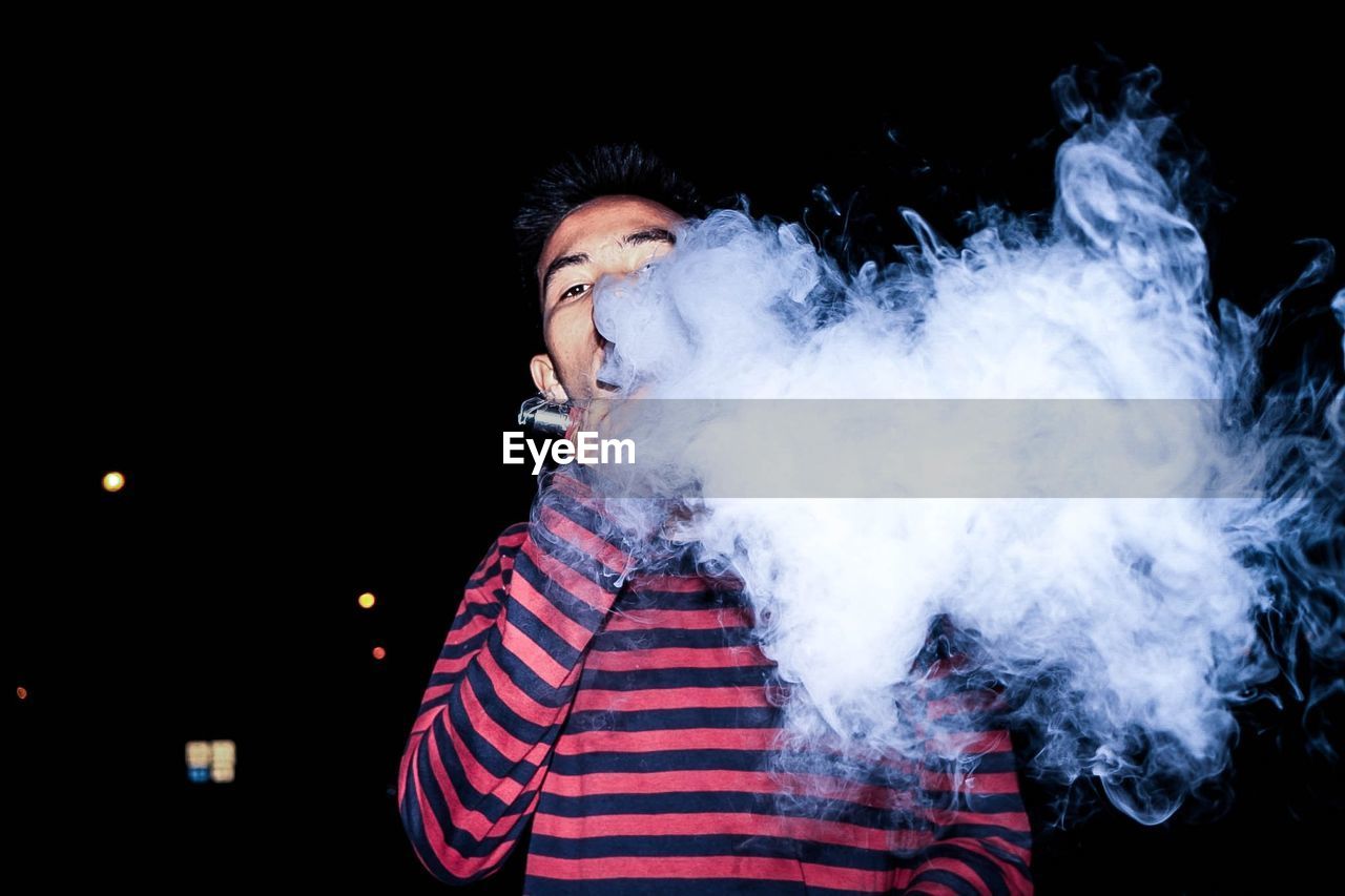 YOUNG MAN SMOKING CIGARETTE