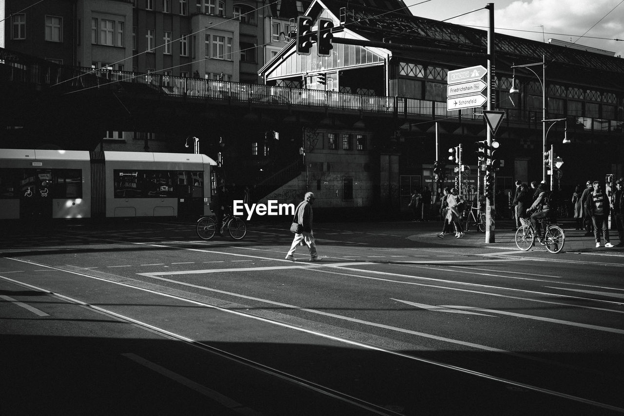 People walking on street by buildings in city