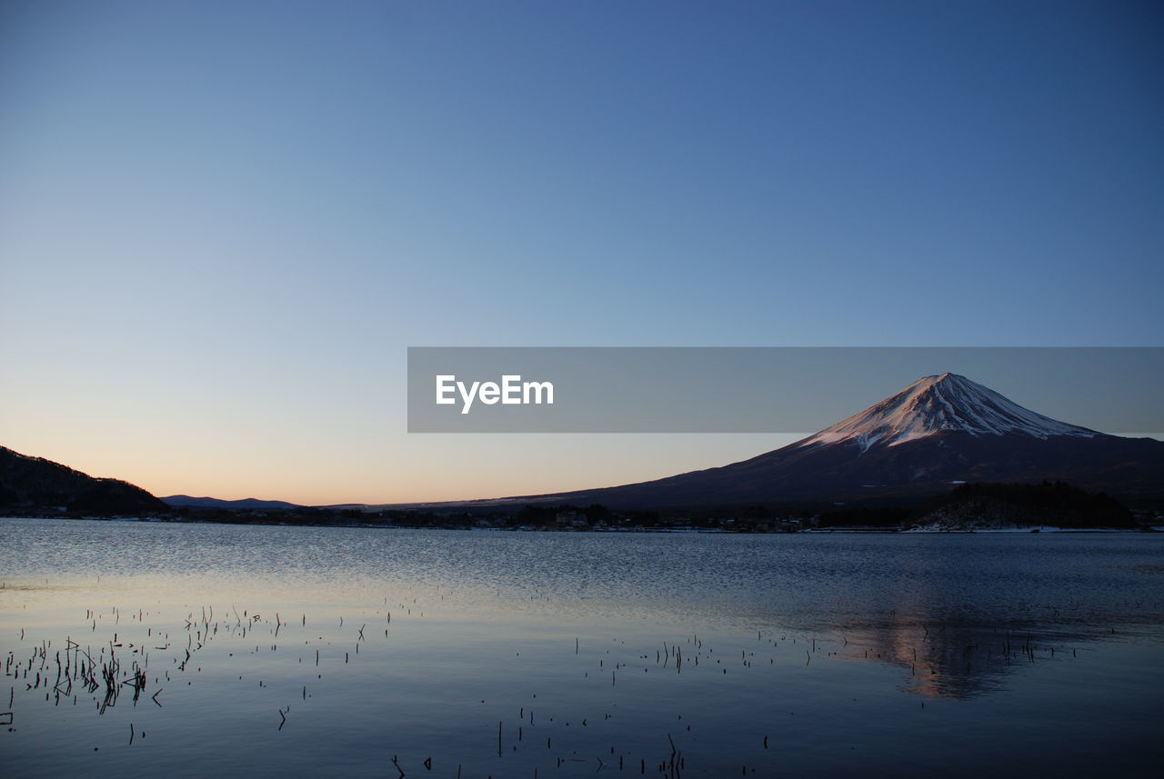 Scenic view of lake and mt fuji against blue sky during sunset