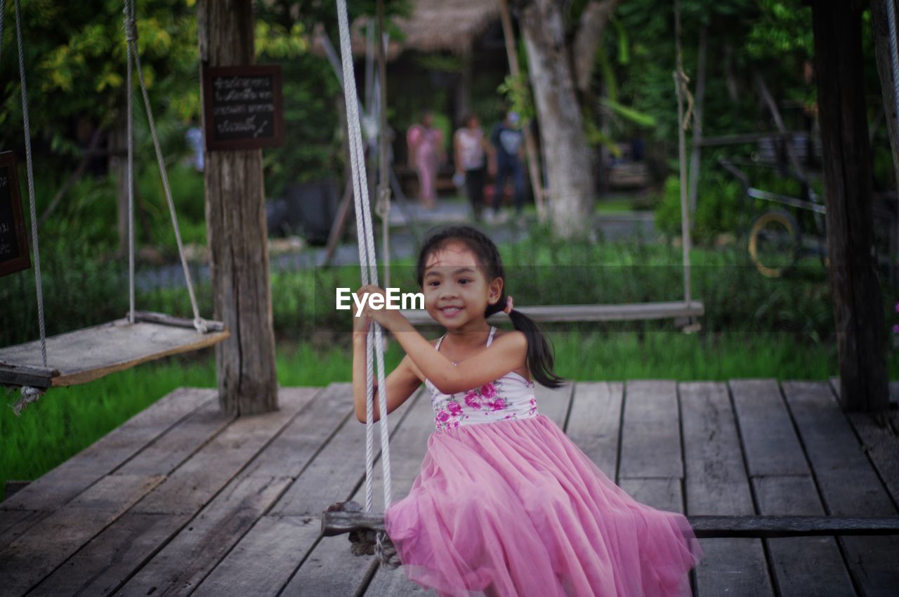 Portrait of smiling girl standing on wood