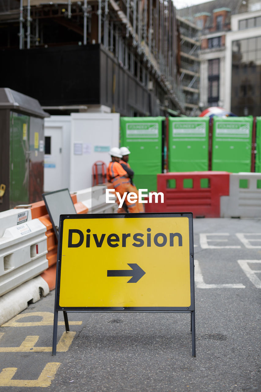 Information sign on road against buildings in city