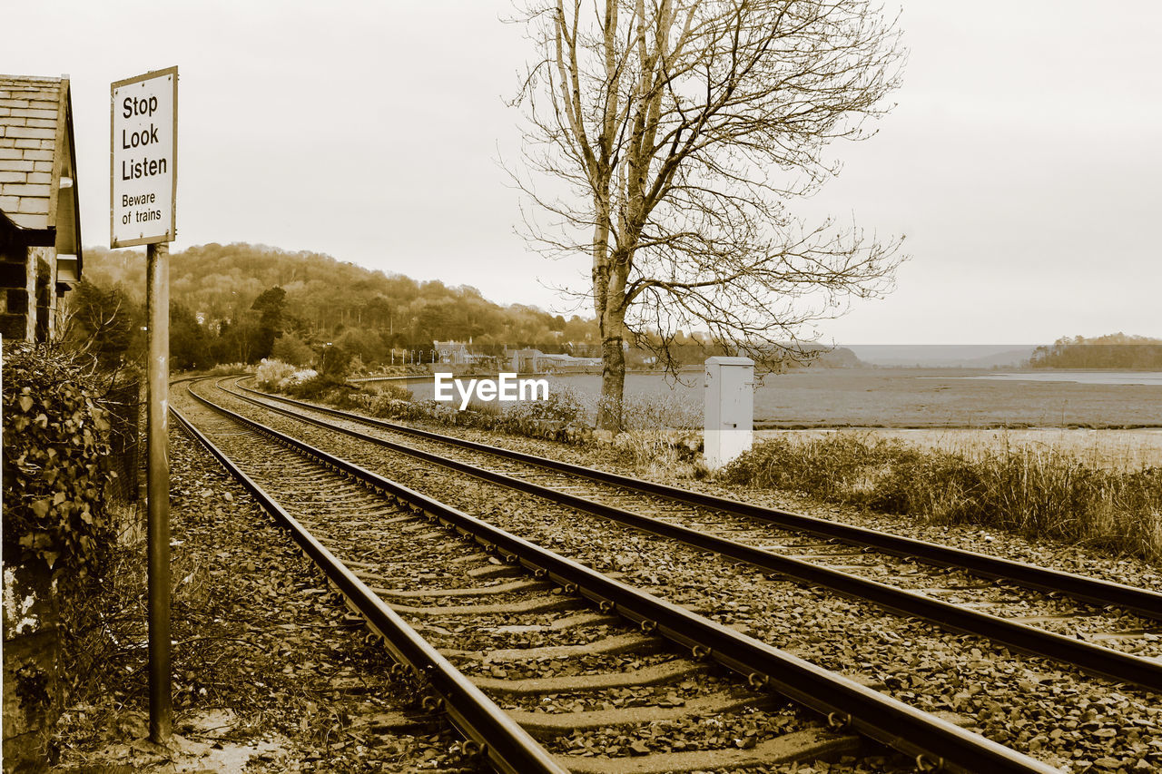 Railroad tracks by trees against sky