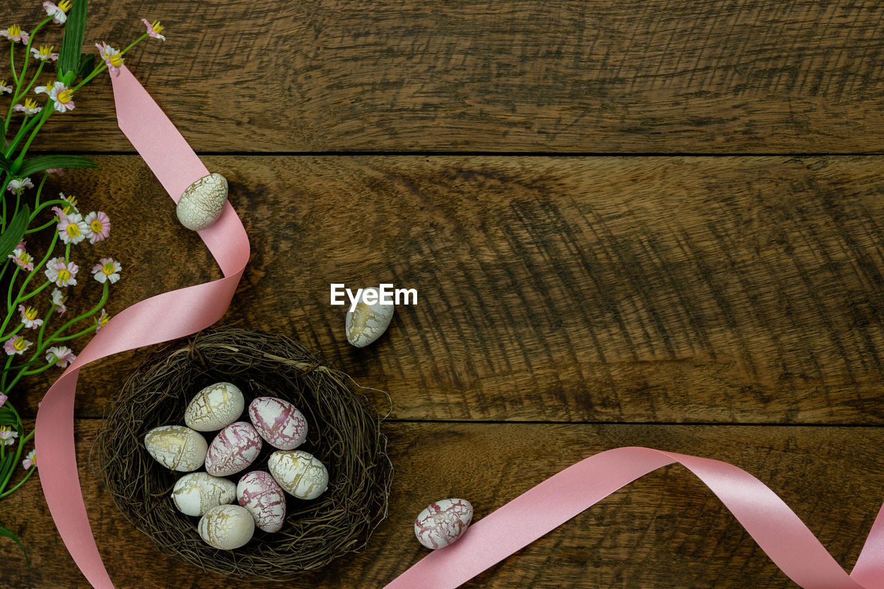 HIGH ANGLE VIEW OF EASTER EGGS ON WOODEN TABLE