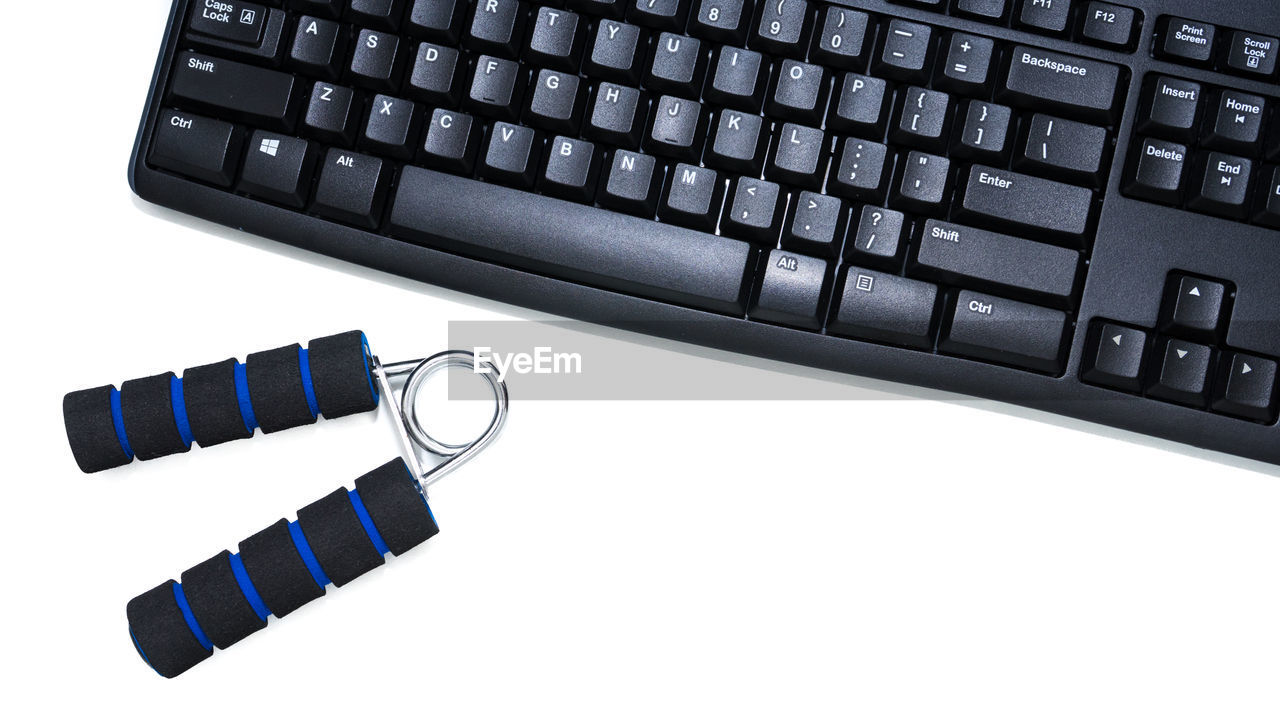 Close-up of laptop keyboard and handgrip over white background