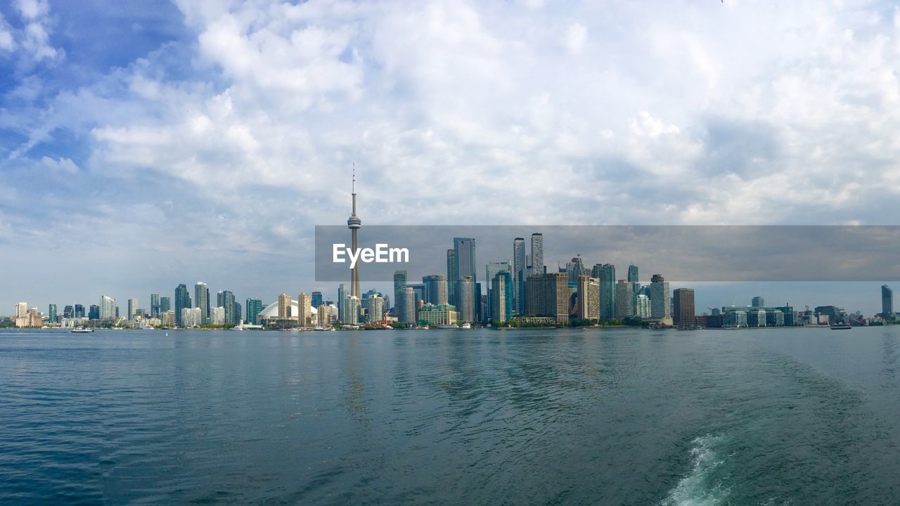 View of buildings in city against cloudy sky