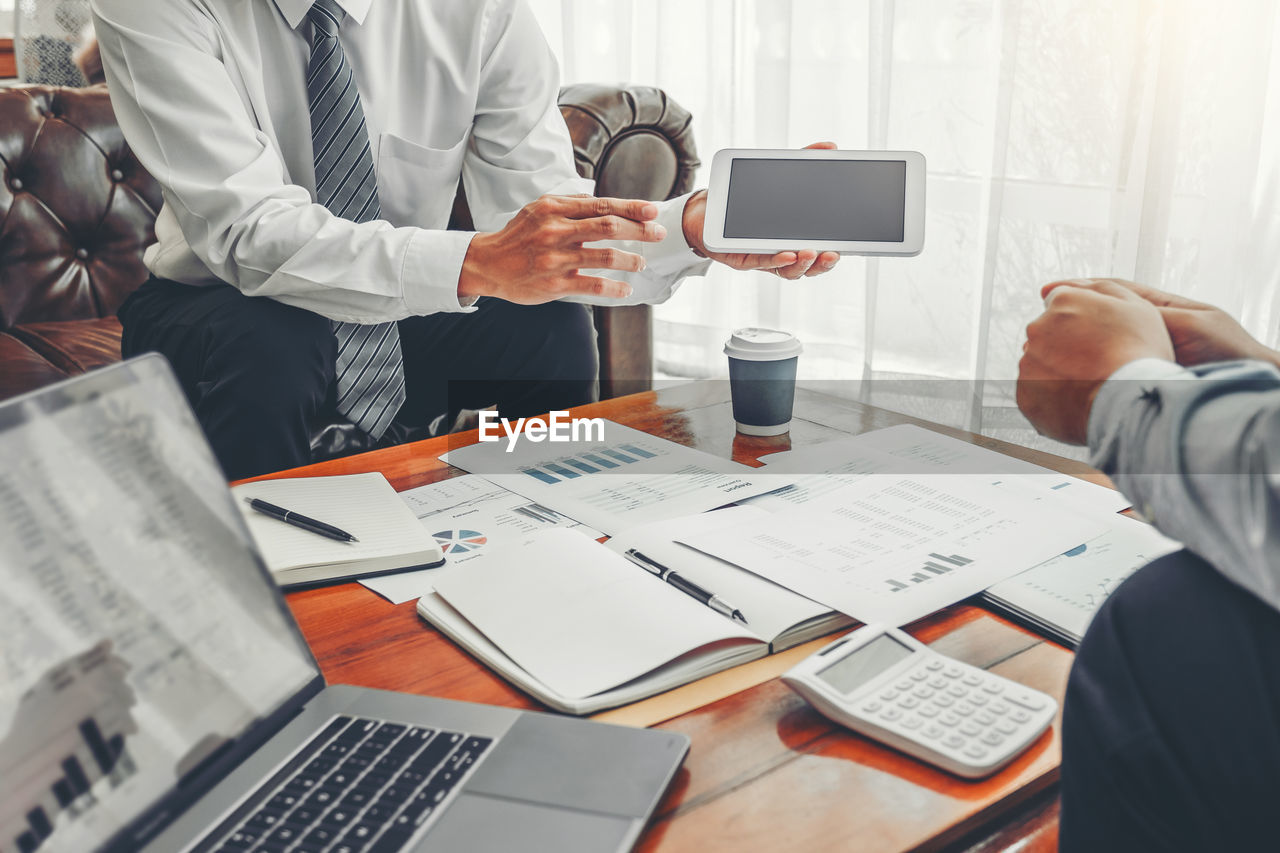 Cropped image of business colleagues working at desk in office