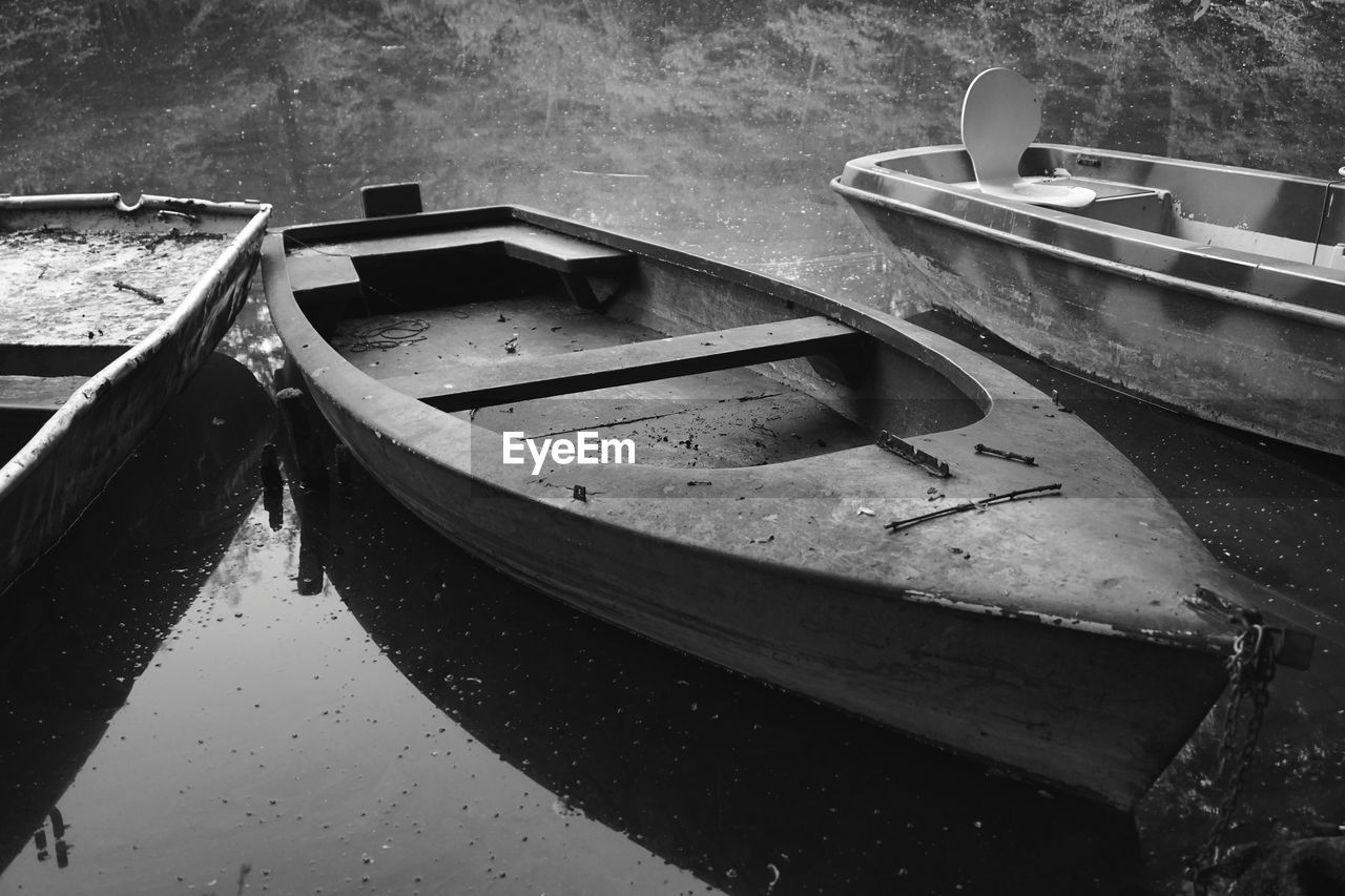 HIGH ANGLE VIEW OF ABANDONED BOAT MOORED ON LAKE