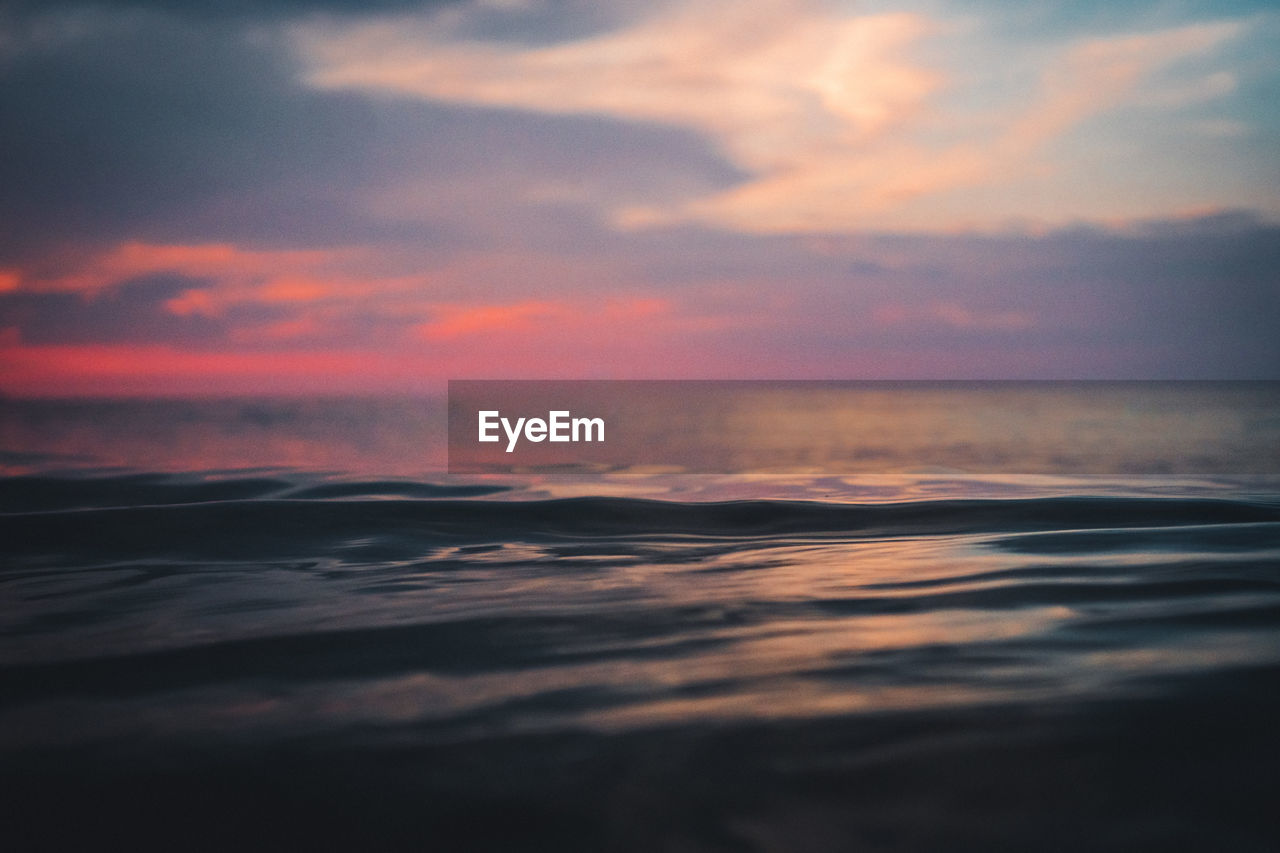 Scenic view of the  calm baltic sea against dramatic sky during sunset