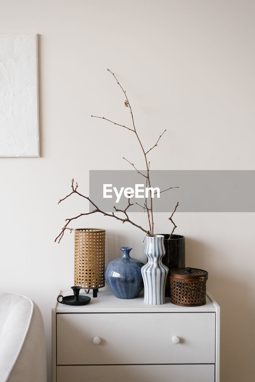 White dresser with blue and brown vase on top of it in modern scandinavian living room