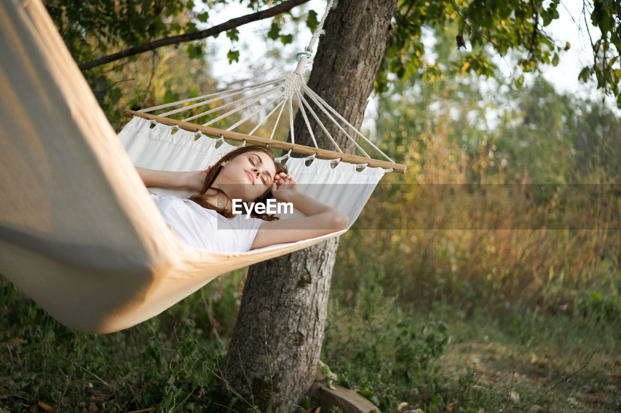 Young woman relaxing on hammock outdoors