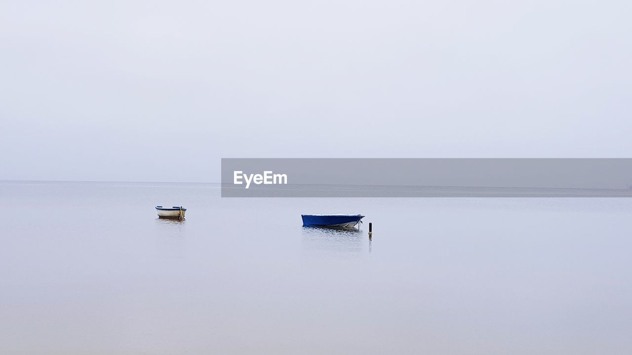 Boat moored in lake against clear sky