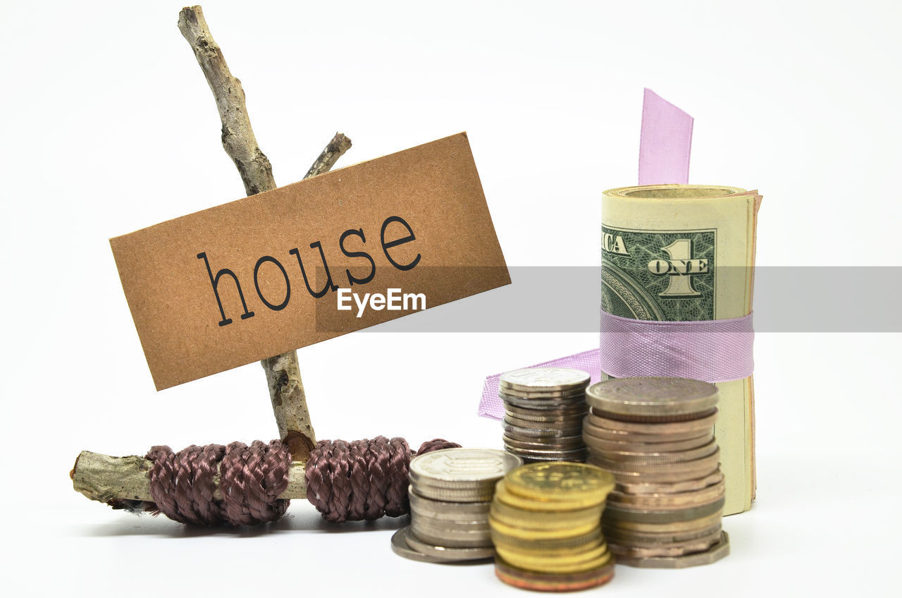 Stacked coins with house text against white background