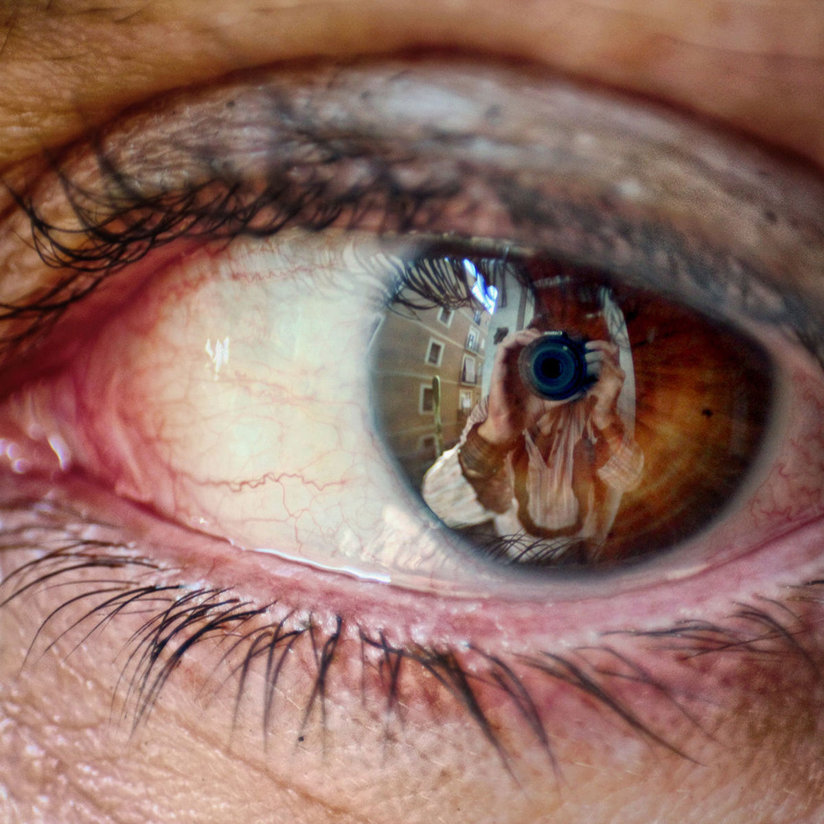 Reflection of photographer photographing human eye