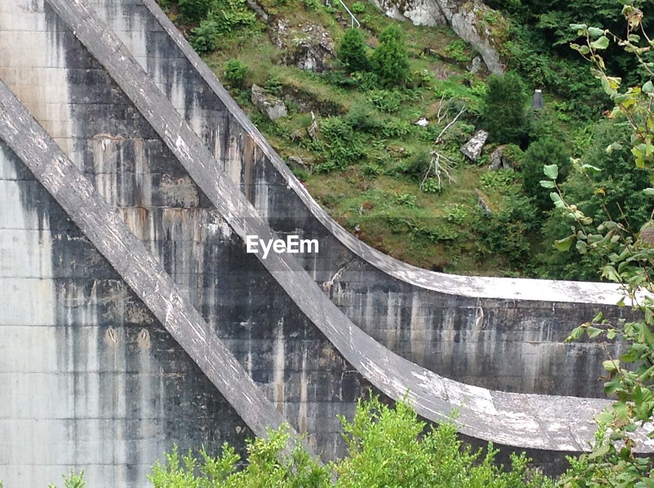 HIGH ANGLE VIEW OF BRIDGE OVER GRASS BY WATER