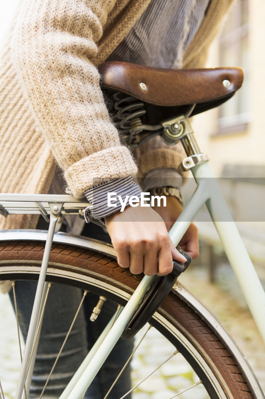 Businesswoman opening bicycle lock outdoors