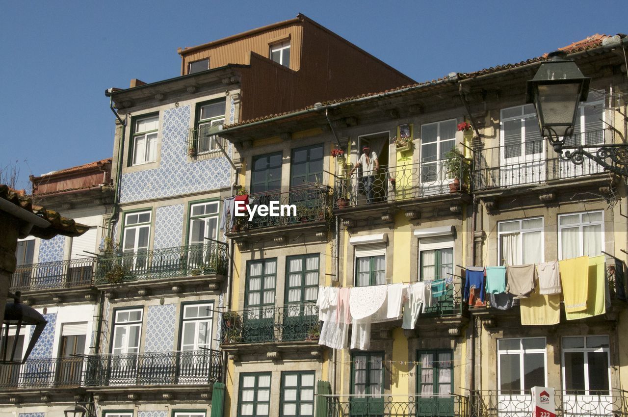 LOW ANGLE VIEW OF CLOTHES DRYING ON HOUSE