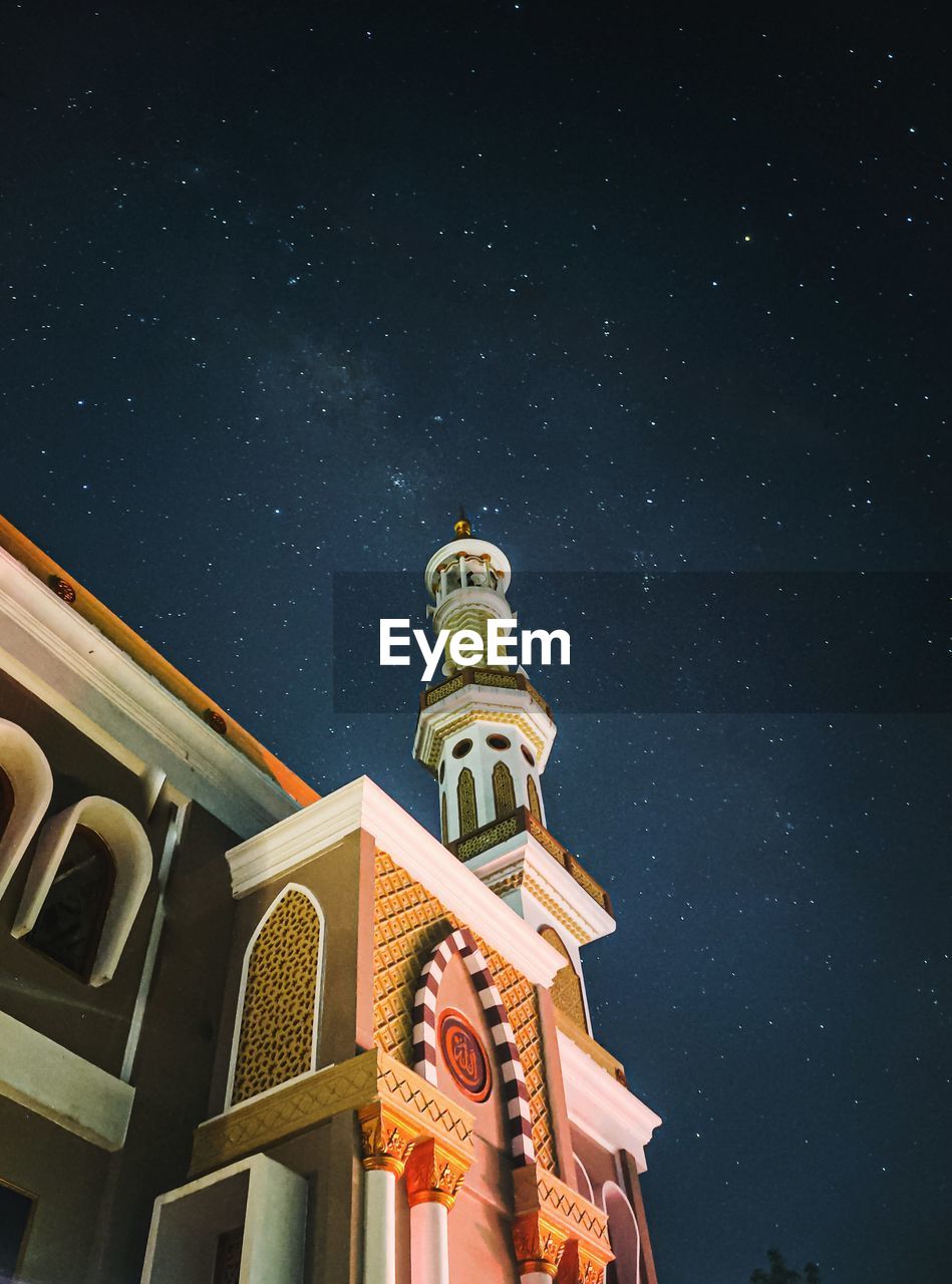 LOW ANGLE VIEW OF ILLUMINATED BUILDING AGAINST SKY