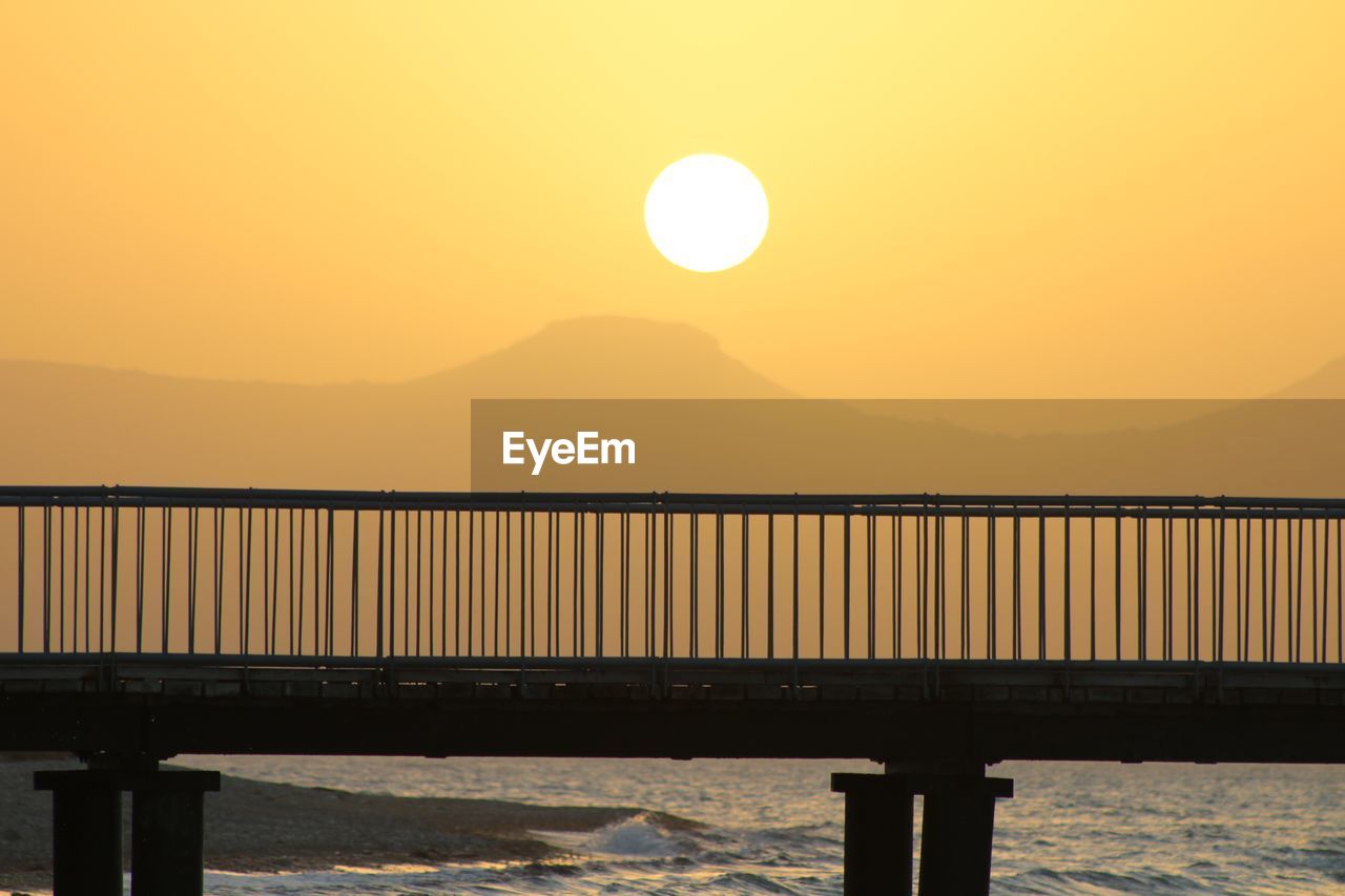 SCENIC VIEW OF SEA AGAINST ORANGE SKY DURING SUNSET