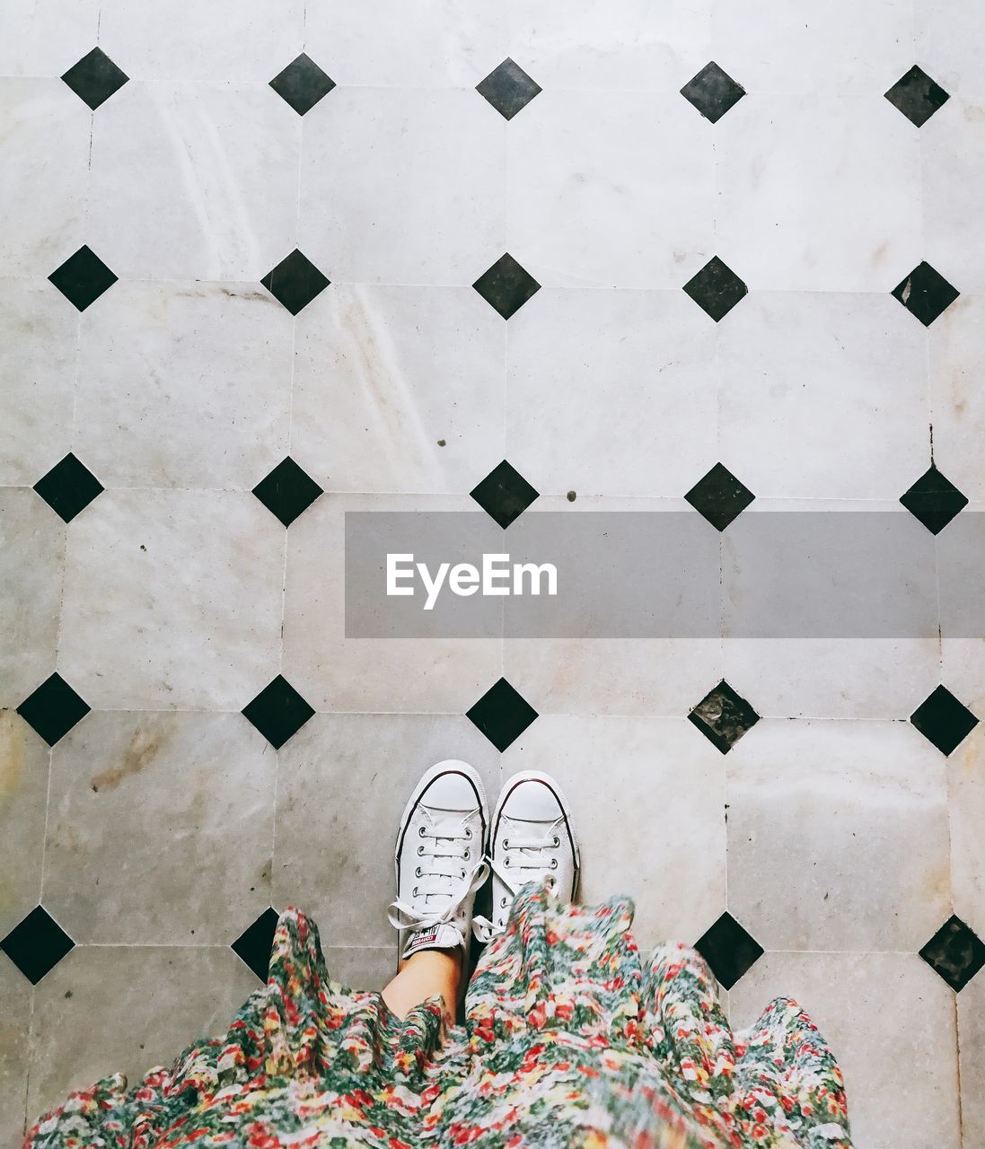 Low section of woman standing on tiled floor