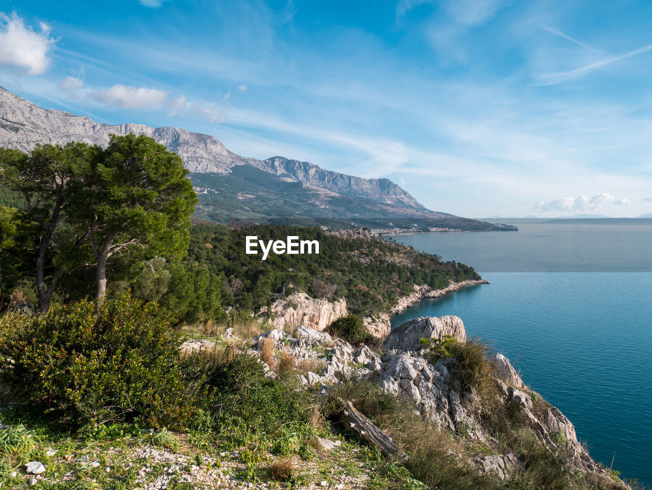 Scenic view of sea and mountains against sky