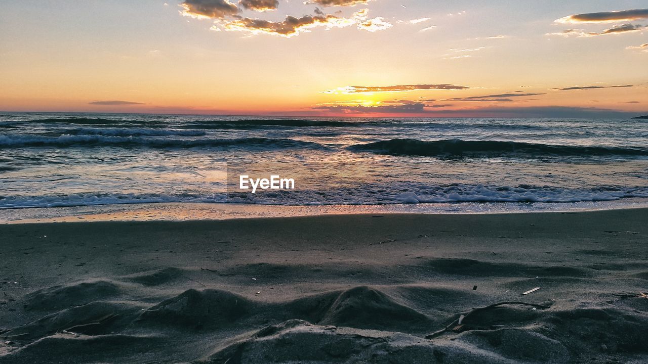 Scenic view of beach against sky during sunset