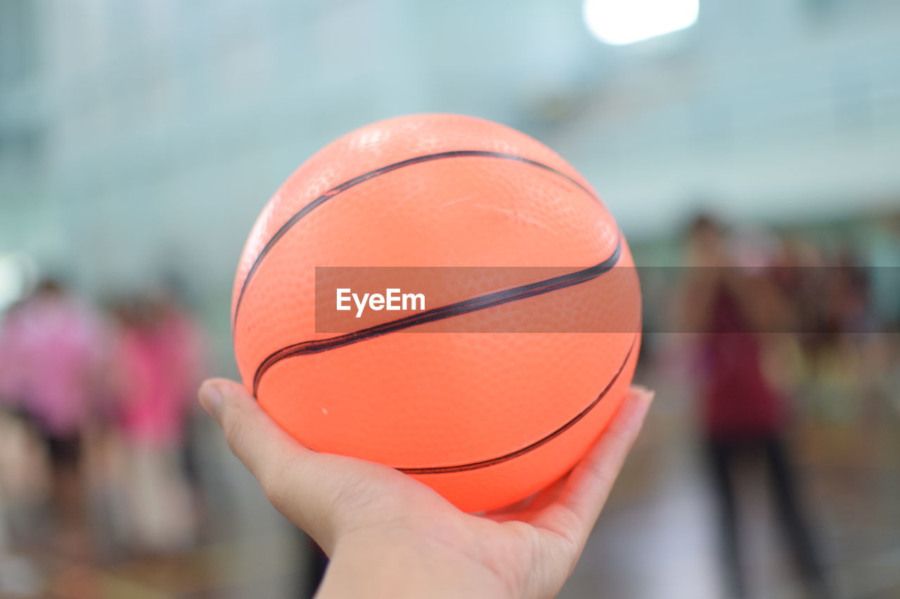 CLOSE-UP OF HAND HOLDING BALL WITH UMBRELLA