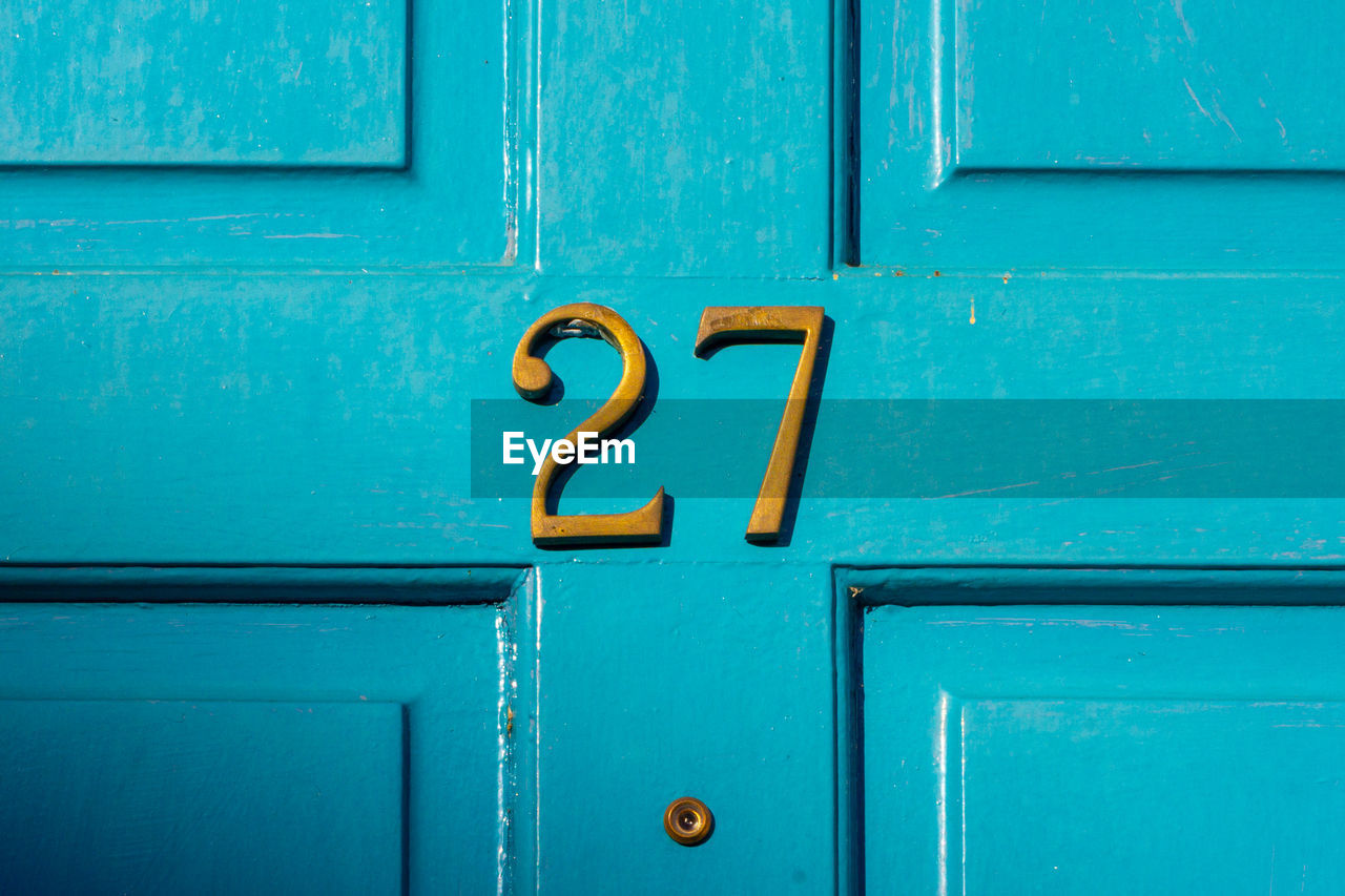 House number 27 on a blue wooden front door in london 