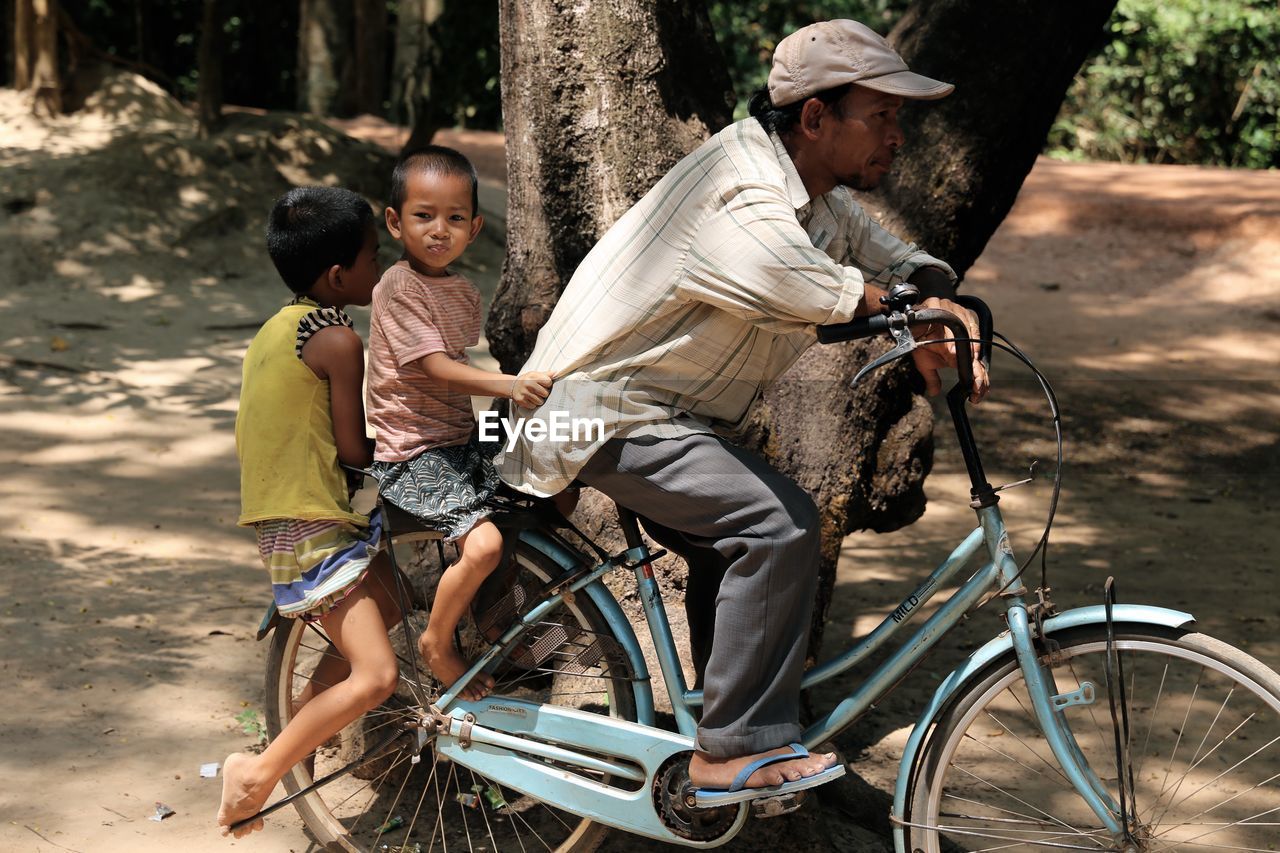 FULL LENGTH OF BOY SITTING ON BICYCLE