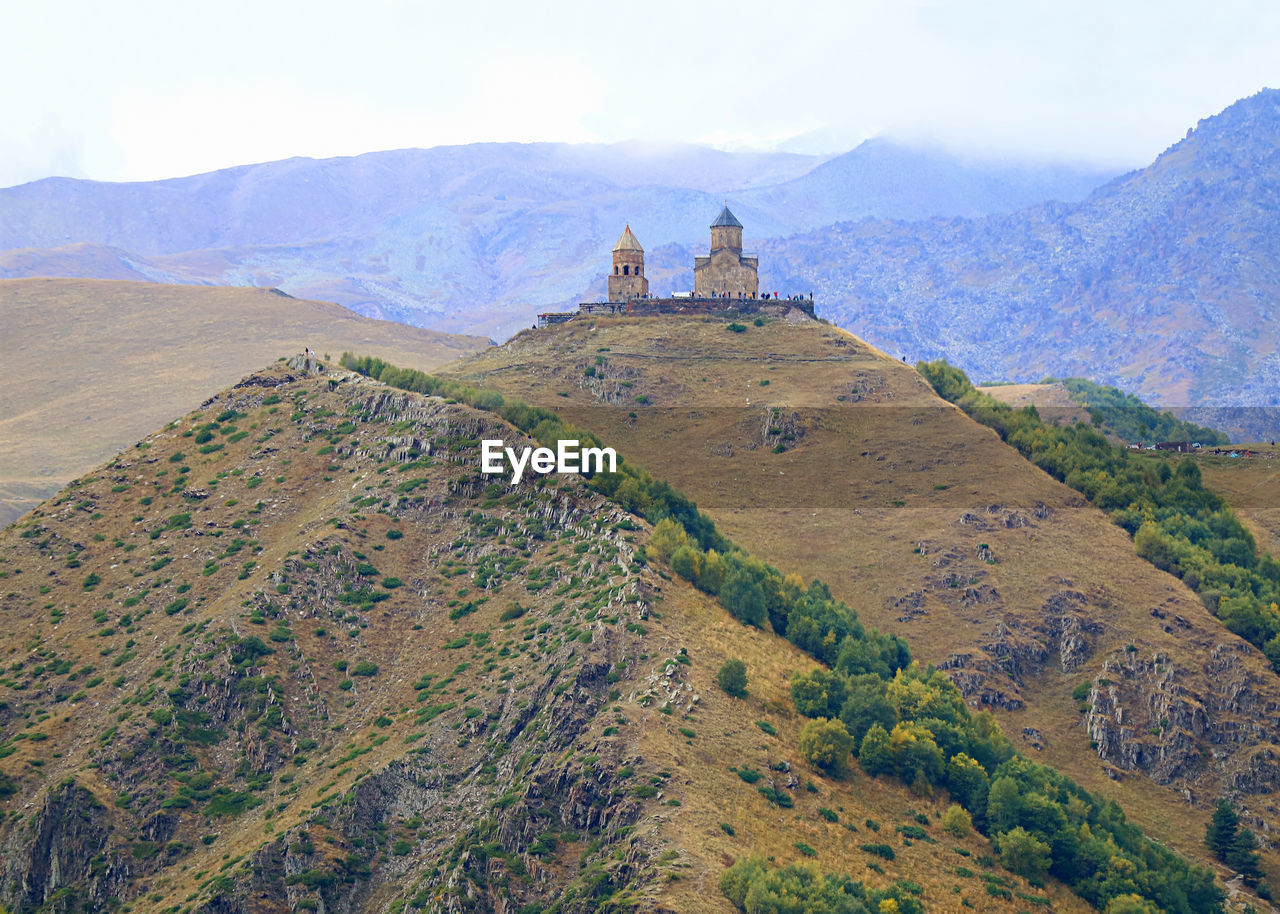 Incredible view of the gergeti trinity church on the hilltop, stepantsminda town, georgia