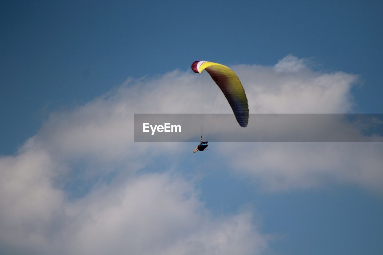 LOW ANGLE VIEW OF PARAGLIDING IN SKY