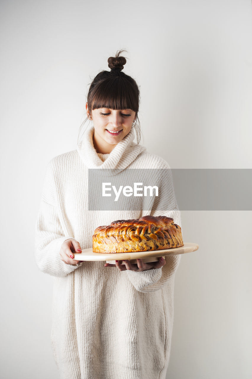 PORTRAIT OF YOUNG WOMAN HOLDING FOOD