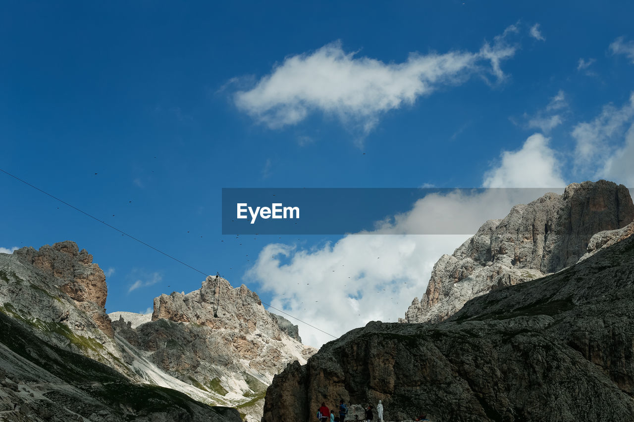 LOW ANGLE VIEW OF ROCKS AND MOUNTAINS AGAINST BLUE SKY