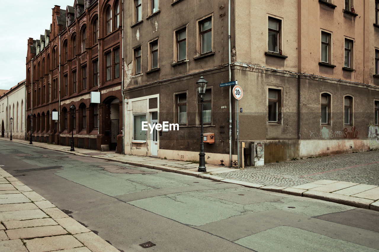 MAN ON ROAD ALONG BUILDINGS