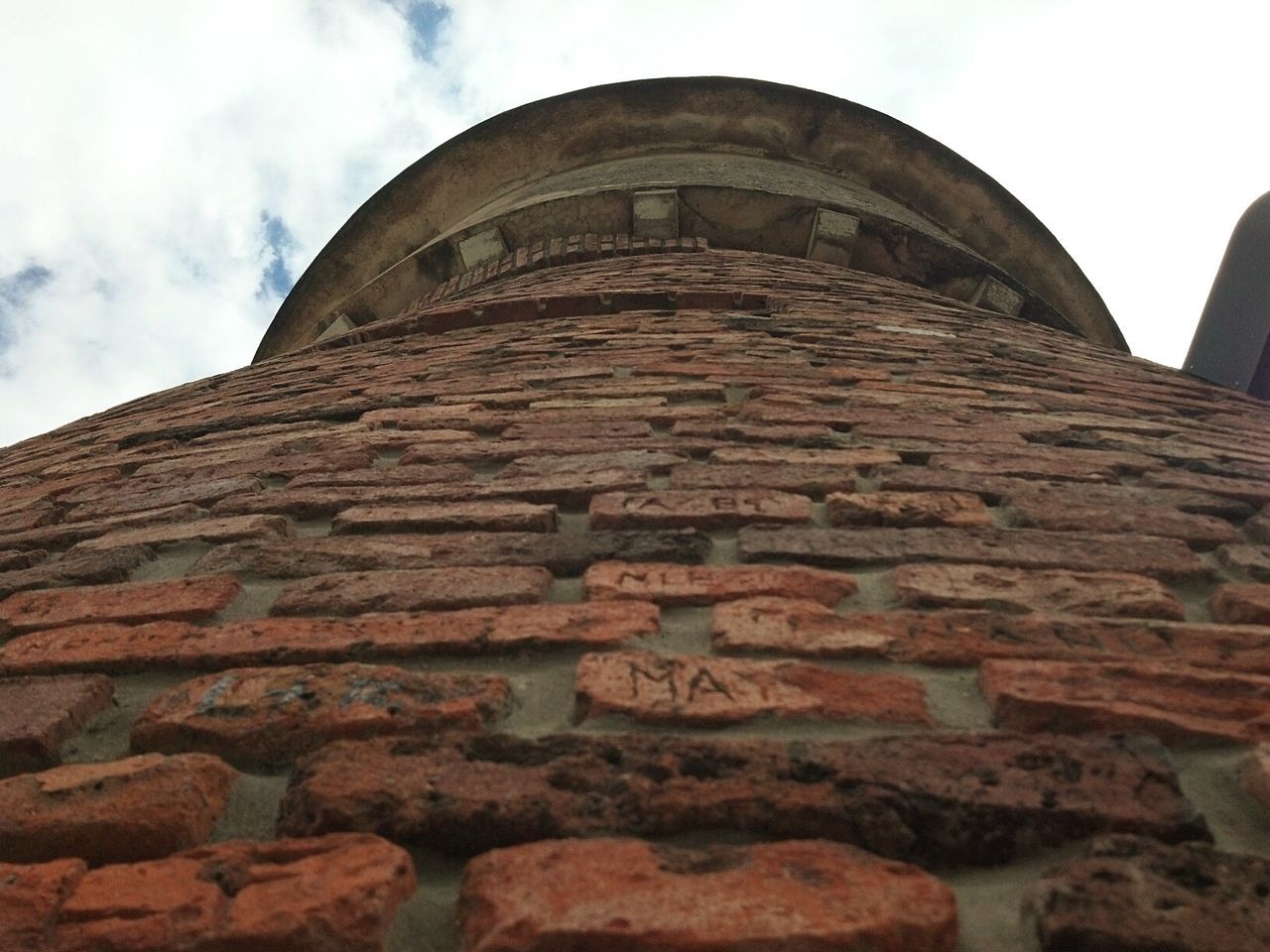 Low angle view of old brick tower against sky