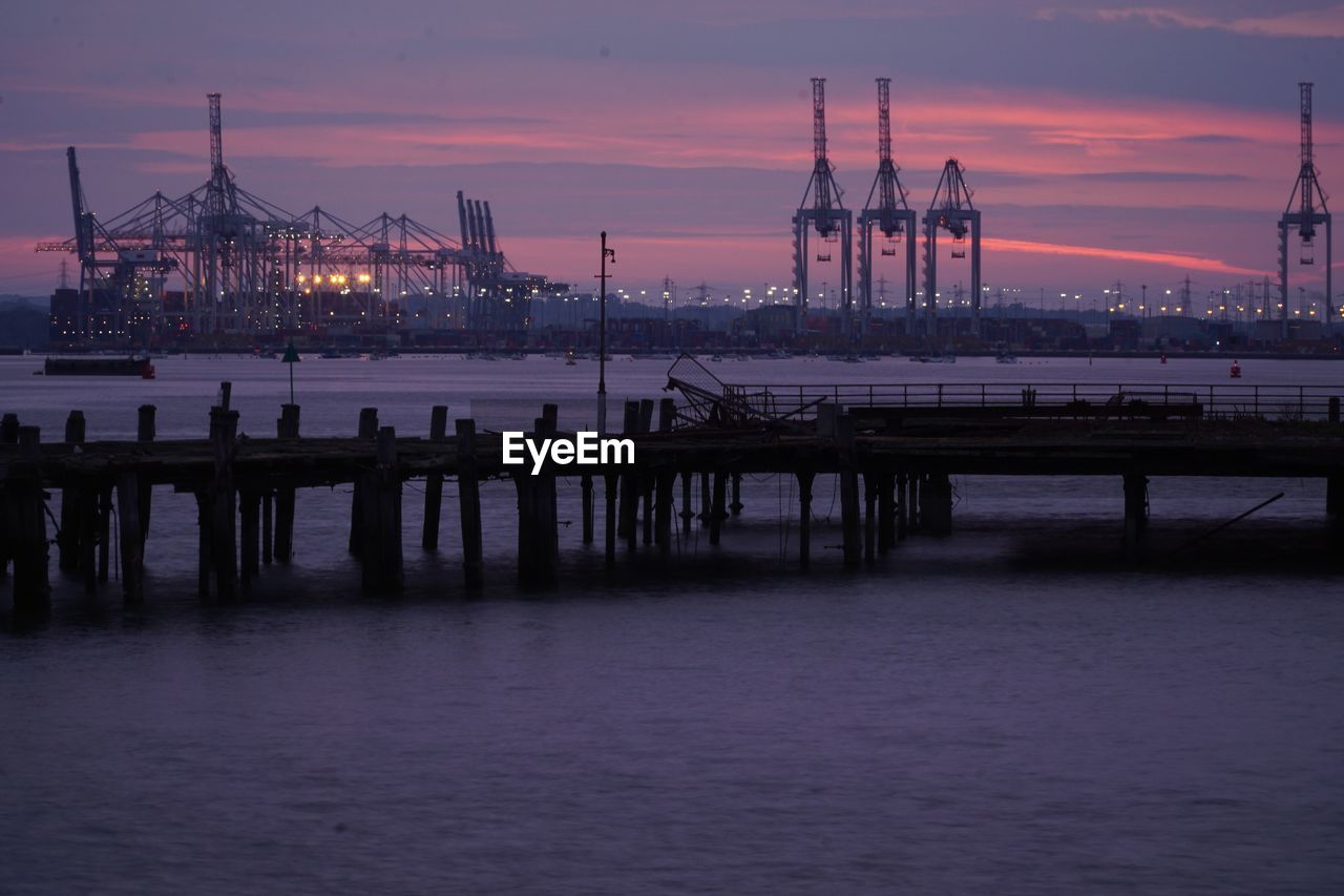 Silhouette pier over sea against sky during sunset