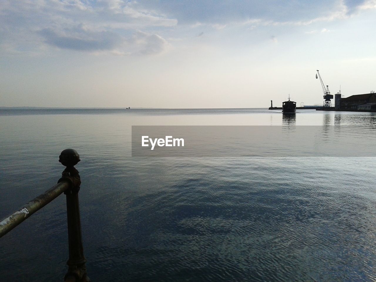 View of harbor against cloudy sky