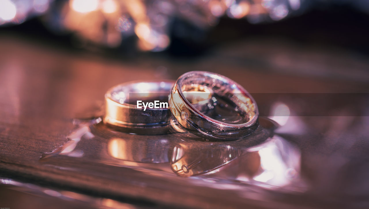 Close-up of wet wedding rings on table