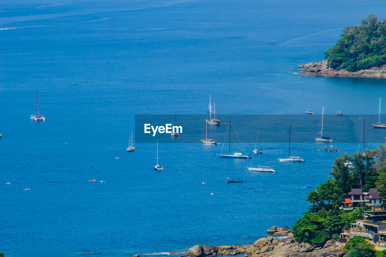 HIGH ANGLE VIEW OF SAILBOATS MOORED ON SEA