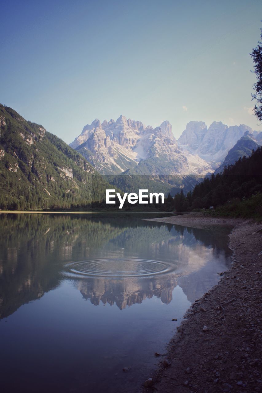 Scenic view of lake and mountains against clear sky