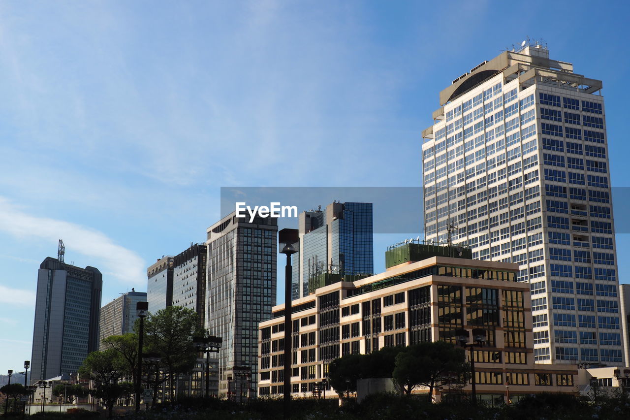 Low angle view of skyscrapers against blue sky