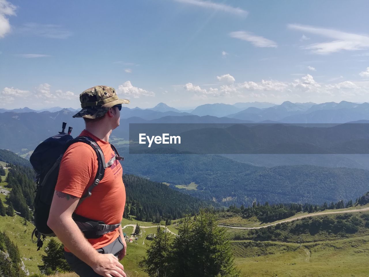Side view of male hiker looking at mountains against sky