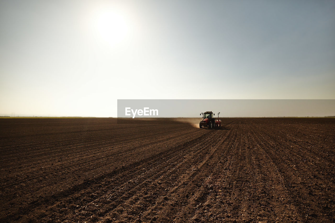 Tractor sowing seeds at soybean farm