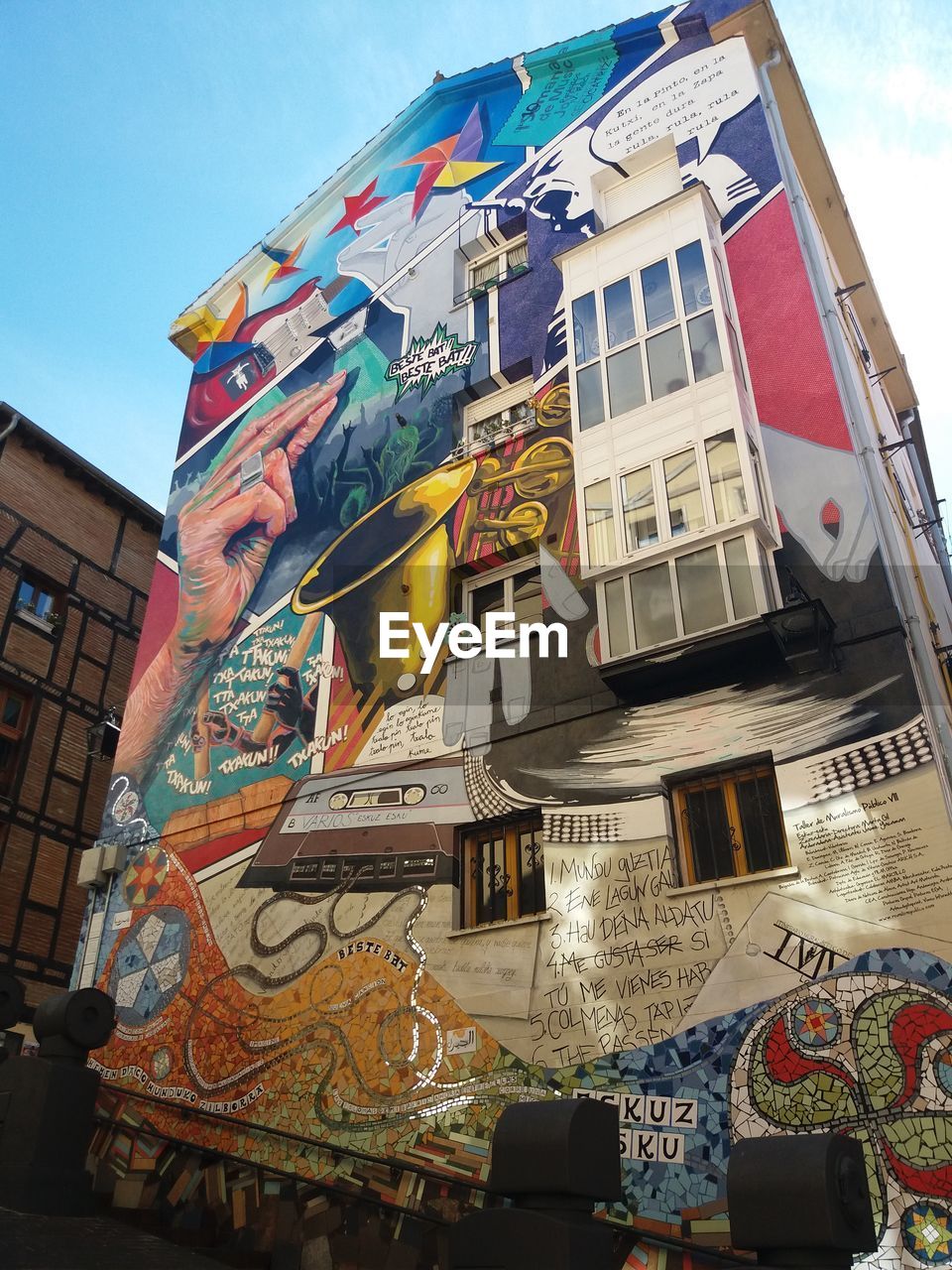 LOW ANGLE VIEW OF GRAFFITI ON BUILDING AGAINST SKY IN CITY