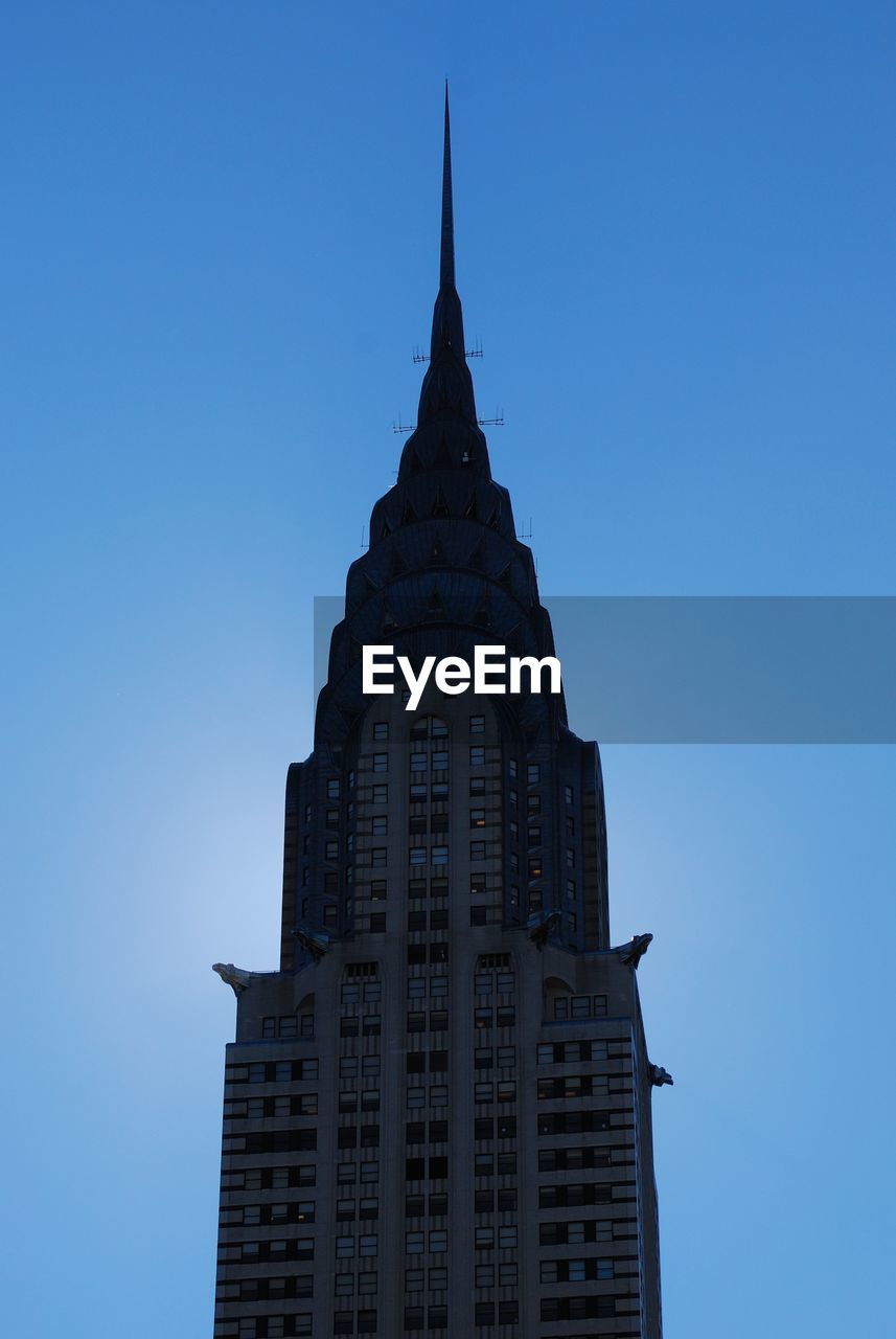 View of the chrystler building with the sun behind it early one morning. 